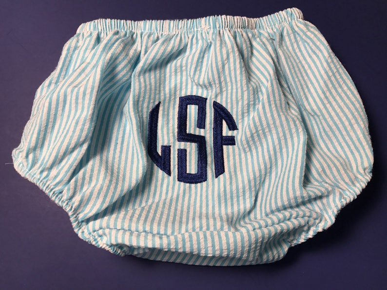 May include: Blue and white striped baby bloomers with a navy blue monogram "LSF" embroidered on the front.