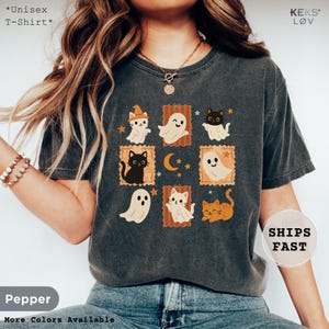 unisex t-shirt with retro Halloween design featuring cute black cats, orange cats, and friendly ghosts in vintage postcard style