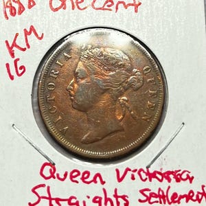 May include: An 1893 one cent copper coin from the Straits Settlements, depicting Queen Victoria. The coin is inscribed "VICTORIA QUEEN" and has a KM number of 16.