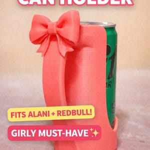 May include: A coral-colored can holder with a bow detail and handle, holding a green can. Text on the holder reads "CUTEST CAN HOLDER", "FITS ALANI + REDBULL!", and "GIRLY MUST-HAVE".