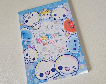 Könnte beinhalten: Ein farbenfroher Notizblock mit Cartoon-Charakteren mit blasenartigen Körpern und verschiedenen Gesichtsausdrücken. Der Notizblock hat einen hellblauen Hintergrund mit einem glitzernden Streifen oben. Japanischer Text ist sichtbar.