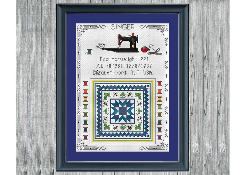 May include: Framed cross-stitch art featuring a black Singer sewing machine, spools of thread, and a quilt block design in blue, green, and white. Text includes "Featherweight 221" and "Elizabethport NJ USA".