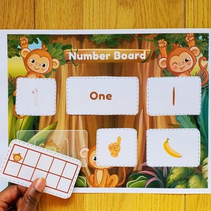 May include: A colorful educational board with a jungle theme featuring monkeys and the word "Number Board". The board has a number of squares with numbers, words, and pictures. There is also a separate grid with nine squares.