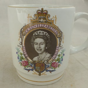 Puede incluir: Taza de cerámica blanca con ribete dorado y una imagen colorida de la reina Isabel II. La imagen incluye el texto "Queen Elizabeth II", "1952 Silver Jubilee 1977" y un escudo de armas.