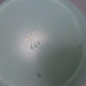 May include: Close-up of a light blue plastic container with a circular embossed logo featuring a stylized bird and the number "101".