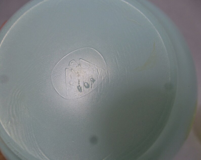 May include: Close-up of a light blue plastic container with a circular embossed logo featuring a stylized bird and the number "101".