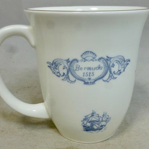 May include: White ceramic mug with a blue and white design featuring a ship and the text "Bermuda 1515".