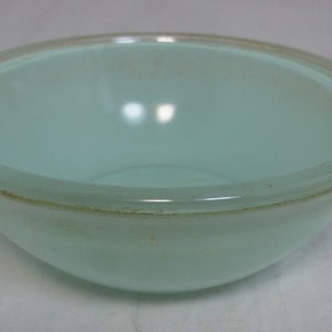 May include: A light blue glass mixing bowl with a slightly raised rim.