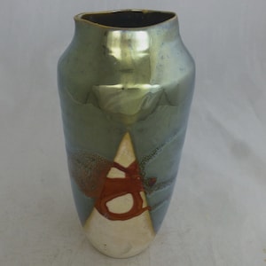 Puede incluir: Un jarrón de cerámica con un esmalte verde iridiscente y un diseño blanco y rojo. El jarrón tiene una boca ancha y una base estrecha.