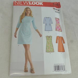 Op de afbeelding: Een New Look naaipatroon-envelop voor een jurk, met een lichtblauw en wit gestreepte jurk met driekwartmouwen en zakken. De envelop toont vier variaties van het jurkontwerp, inclusief bloemmotieven en effen kleuropties.