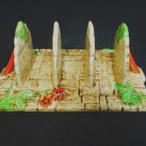 May include: A ceramic toast rack with four slots, decorated with a brick wall pattern and green and red floral accents.