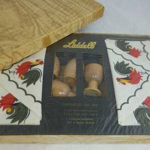 Puede incluir: Un juego vintage Liddell 'Desayuno para dos' en una caja de madera. El juego incluye dos manteles individuales de lino, dos servilletas de lino, cuatro hueveras de madera, dos saleros y pimenteros de madera y un diseño de gallo.