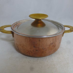 Puede incluir: Una olla de cobre con asas de latón y una tapa de acero inoxidable con un pomo de latón. La olla tiene un acabado martillado.