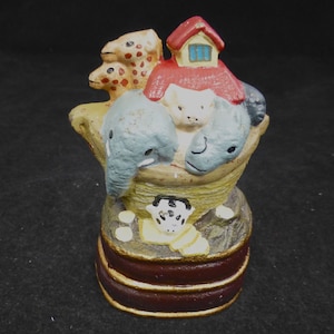 Può includere: Un fermaporta in ghisa a forma di arca di Noè con un tetto rosso e una varietà di animali, tra cui una giraffa, un elefante e un maiale. Il fermaporta è dipinto con colori vivaci e ha un design dettagliato.