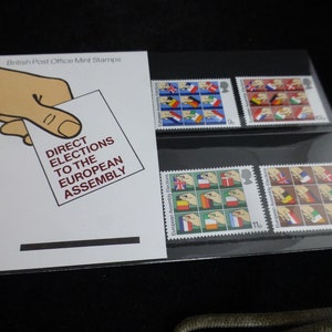 Puede incluir: Un conjunto de cuatro sellos de correos británicos en perfecto estado que conmemoran las primeras elecciones directas a la Asamblea Europea. Los sellos muestran una mano sosteniendo una papeleta de votación con las banderas de los estados miembros de la Comunidad Europea. Los sellos están en una hoja de plástico transparente con el texto "British Post Office Mint Stamps" y "Direct Elections to the European Assembly".