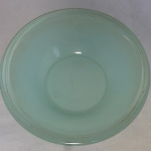 May include: A light blue glass bowl with a frosted finish. The bowl has a slightly raised rim.