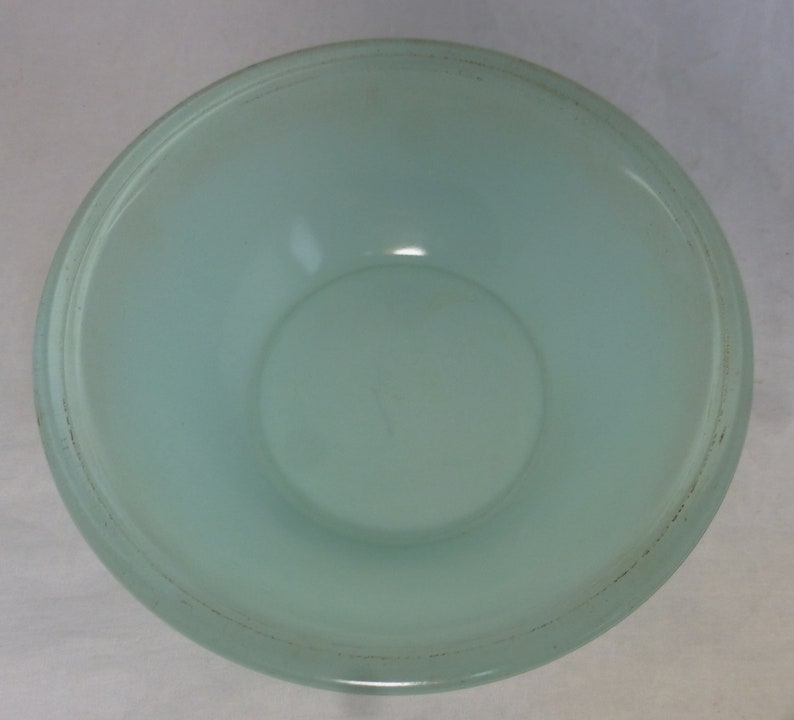 May include: A light blue glass bowl with a frosted finish. The bowl has a slightly raised rim.