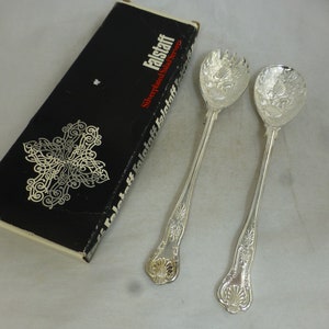 May include: A set of silver-plated salad servers in their original box. The box is black with a silver design and the words "Falstaff Silverplated Salad Servers" printed on it.