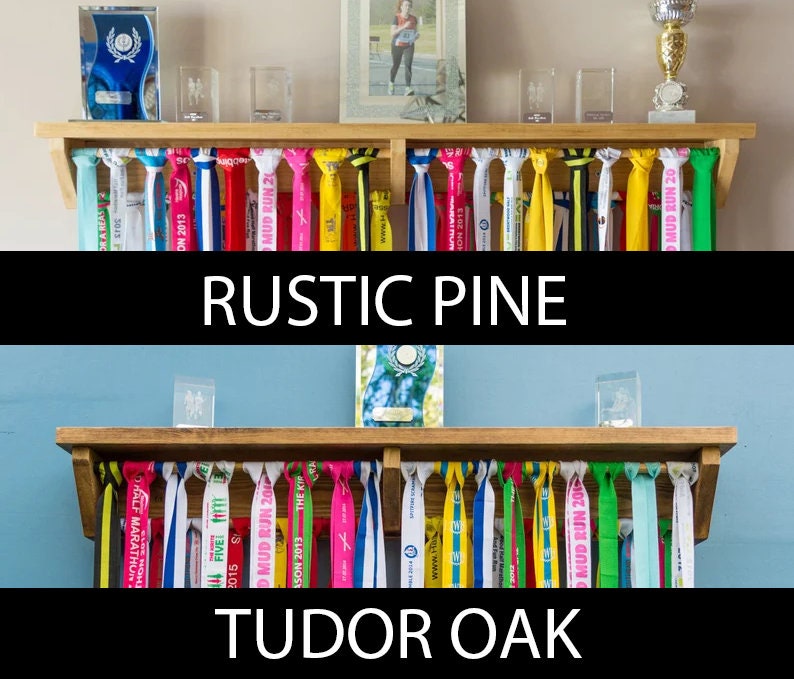 May include: Two wooden medal display shelves with a variety of colorful medals hanging on hooks. The top shelf is labeled "RUSTIC PINE" and the bottom shelf is labeled "TUDOR OAK".