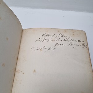 K&ouml;nnte beinhalten: Nahaufnahme einer Buch-Inschriftenseite mit handschriftlichem Text, der "Effiel Tower, Paris, 1885" lautet.