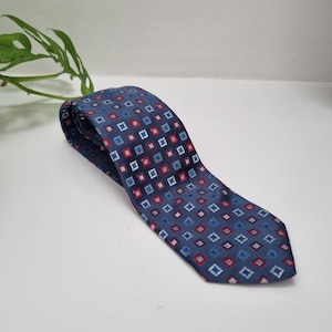 May include: A blue patterned tie with red, white, and blue squares.