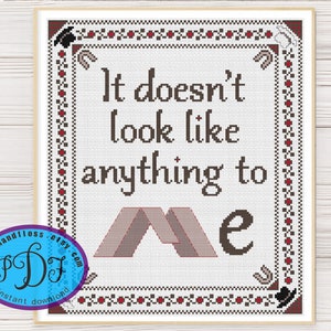 May include: Cross stitch pattern featuring the text "It doesn't look like anything to me" with a stylized image of a tent.