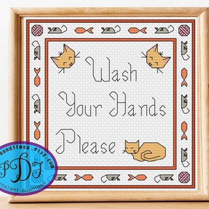 May include: Cross-stitch pattern featuring a cat design with the text "Wash Your Hands Please". The pattern is framed in a light wood frame.