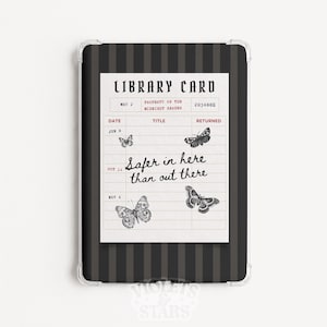 Puede incluir: Una funda para tableta con un fondo de rayas verticales negras y gris oscuro y un gráfico central de ficha de biblioteca. La ficha muestra el texto "LIBRARY CARD", "PROPERTY OF THE MIDNIGHT READER" y "Safer in here than out there" con polillas.
