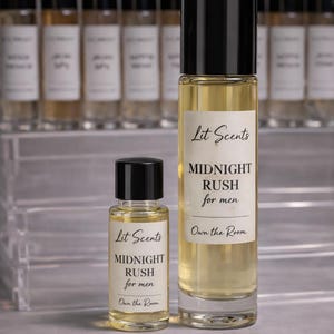 May include: Two bottles of "Midnight Rush for men" fragrance by Lit Scents. The larger bottle is tall and slender, with a black cap and a white label. The smaller bottle has a similar design. The background features additional bottles.
