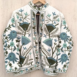 May include: White cotton jacket with a mandarin collar and intricate floral embroidery in shades of blue and green.