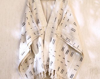 May include: A white cotton kimono with black geometric patterns and fringe trim.