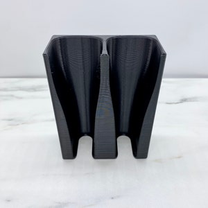 May include: Black plastic 3D printed organizer with three slots.