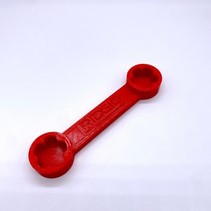May include: A red wrench with a star-shaped opening on each end. The wrench is labelled "RIGID".