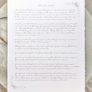 Custom calligraphy wedding vows with the wedding date at the top and floral details in the corners.