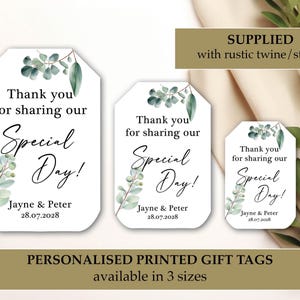 Puede incluir: Etiquetas de regalo blancas con el texto "Thank you for sharing our Special Day!" en escritura elegante, adornadas con ramitas de eucalipto. Las etiquetas están personalizadas con nombres y una fecha, disponibles en tres tamaños.