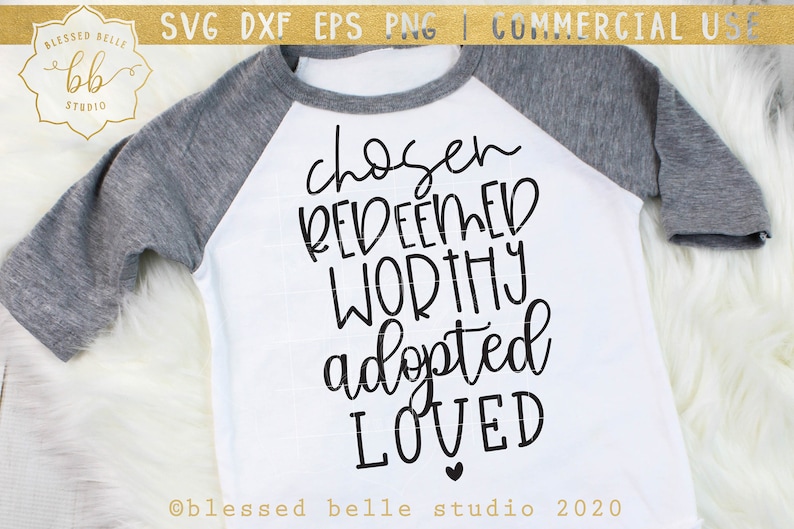 May include: A white t-shirt with a black design that says "chosen redeemed worthy adopted loved" with a small heart at the bottom. The text is in a handwritten style.