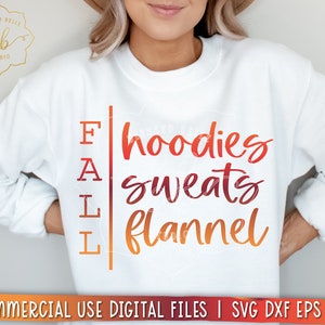 Puede incluir: Sudadera blanca con el texto "FALL" en una columna vertical en el lado izquierdo y el texto "hoodies sweats flannel" en una fuente m&aacute;s grande en el lado derecho. El texto est&aacute; en un degradado de naranja, rojo y amarillo.