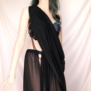May include: A black sheer maxi skirt with a black beaded chain detail and a black sheer top with a beaded embellishment.