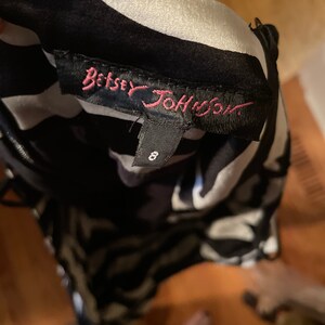 May include: Black and white patterned dress with a pink "Betsey Johnson" label and a size tag that says "8".