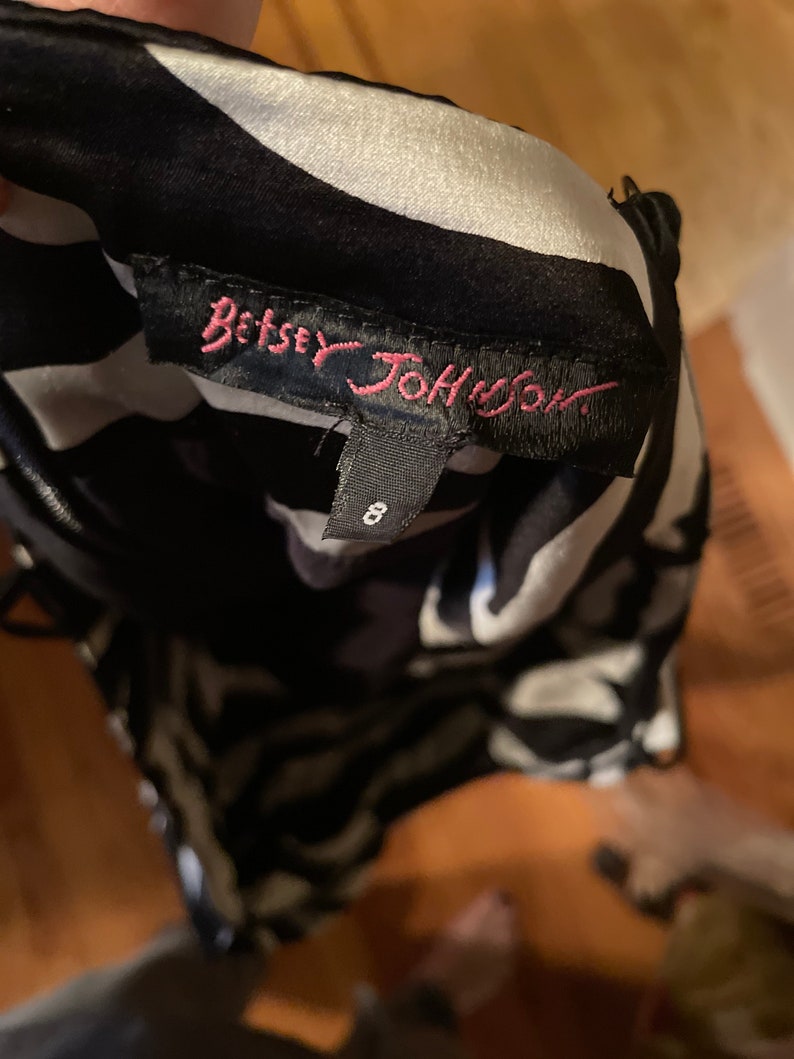 May include: Black and white patterned dress with a pink "Betsey Johnson" label and a size tag that says "8".