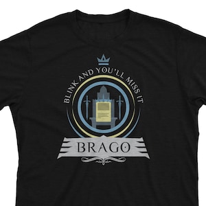 May include: Black t-shirt with a blue and yellow circular design featuring a crown, swords, and the text "Blink and you'll miss it" and "Brago".