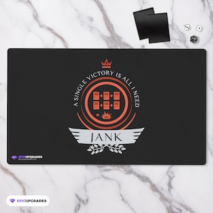 May include: A black playmat with a red and white design. The design features a crown, a circle with the text "A single victory is all I need", and a symbol with the text "Jank".