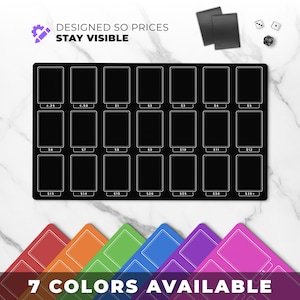 May include: A black card display mat with 20 rectangular slots, each labeled with a price from $0.25 to $35+. The text "DESIGNED SO PRICES STAY VISIBLE" is at the top. Seven colored card holders are at the bottom, with the text "7 COLORS AVAILABLE".