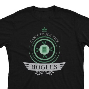 May include: Black t-shirt with a green and white graphic design. The graphic features a crown, a circle with arrows, a square, and the text "Can't Touch This" and "Bogles".