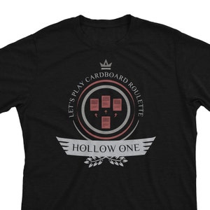 May include: Black t-shirt with a white graphic design featuring a crown, the text "Let's Play Cardboard Roulette", and the text "Hollow One".