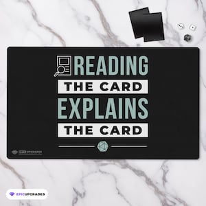 May include: Black and white playmat with the text "Reading the card explains the card" in white with a magnifying glass and a document icon in the top left corner. A green d20 dice icon is in the bottom center.