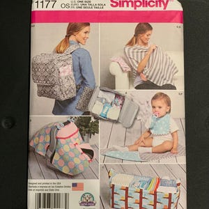 May include: Simplicity sewing pattern 1177 for baby accessories. The envelope features illustrations of a diaper bag, a nursing cover, a car seat canopy, a baby bib, and a storage caddy. The pattern is labeled U.S. One Size and includes a barcode.