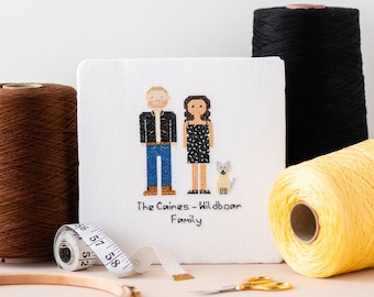Peut inclure: Une toile de point de croix blanche avec une image pixélisée d'un couple et d'un chien. Le texte "The Caines - Wildboar Family" est sous l'image.