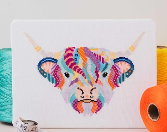 Puede incluir: Un patrón de punto de cruz colorido de una vaca de las tierras altas con un fondo blanco. El pelaje de la vaca es una mezcla de rosa, morado, azul, naranja y amarillo.