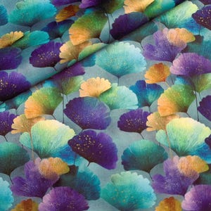 May include: A patterned fabric featuring stylized leaves in teal, purple, yellow, and green. The leaves have a textured appearance and are set against a light blue backdrop. The fabric has a soft, flowing drape, suitable for various craft projects.